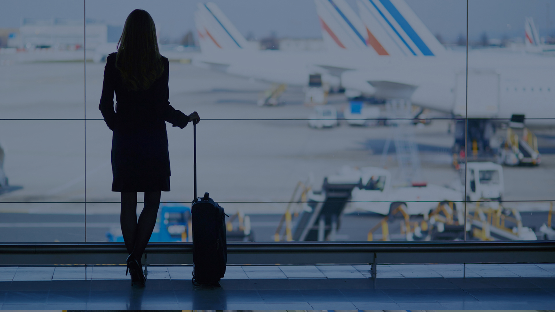woman viewing airport from glass
