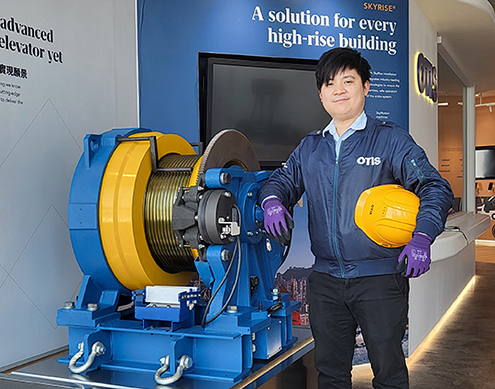 Otis mechanic standing in front of motor