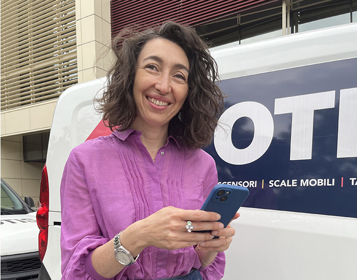Giovanna in front of Otis van with app on phone