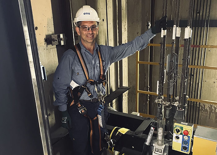 Otis employee doing elevator maintenance