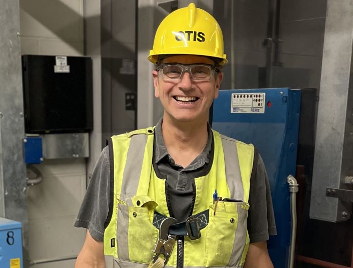 Man in an Otis hard hat and yellow vest 
